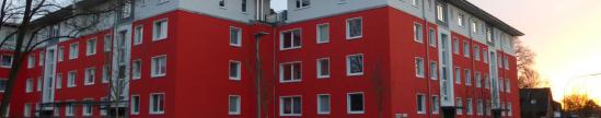 Die Häuser im Fasanenweg mit roter Wärmedämmfassade und Staffelgeschoss.