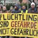 Demonstrierende mit Transparent "Flüchtlinge sind gefährdet, nicht gefährlich"