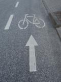 Straßenbelag mit Symbolen - einem Pfeil und einem Fahrrad
