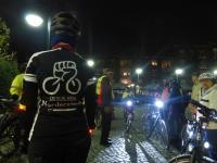 Gruppe Radfahrer, eine Radlerin mit Critical-Mass-Symbol und Schriftzug