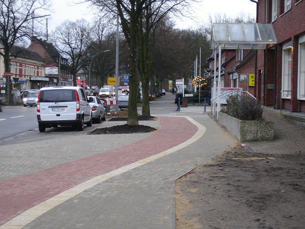 Eigentümliche Wegeführung, Rad- und Fußweg führen um ein paar Parkplätze herum.