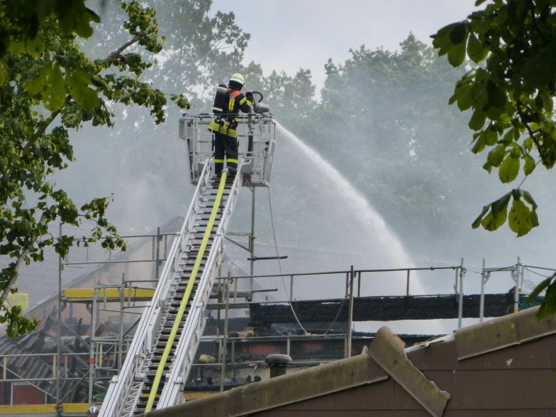 Feuerwehrmann, der von einer Drehleiter aus löschte ...